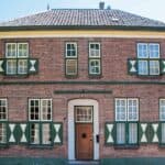 Historisch bakstenen huis met groen-witte luiken