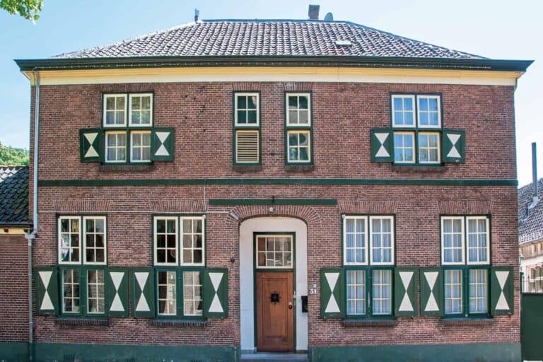 Historisch bakstenen huis met groen-witte luiken