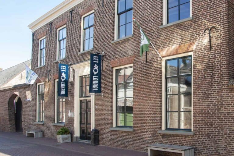 Historisch bakstenen gebouw met vlaggen en ramen