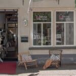 Ingang woonwinkel met stoelen en fiets voor de deur.