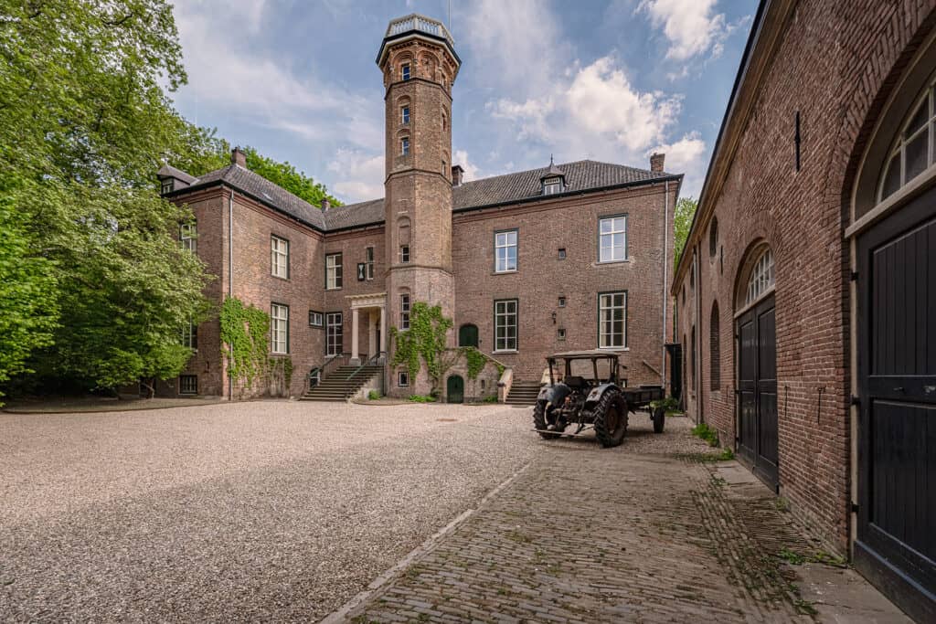 Historisch gebouw met toren en oude tractor