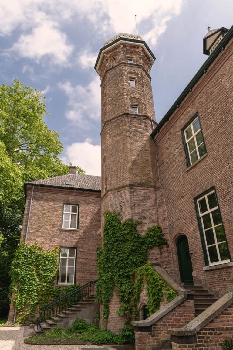 Oud bakstenen gebouw met toren en klimop.