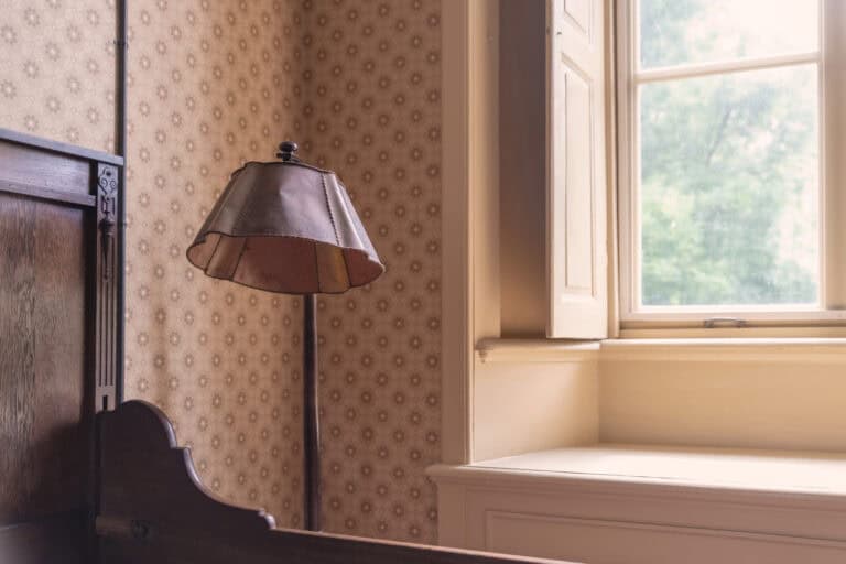 Oude lamp naast raam met gordijnen in slaapkamer